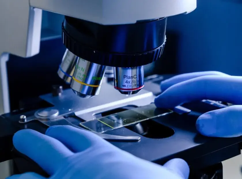 A laboratory worker working with a modern microscope while conducting a coronavirus research